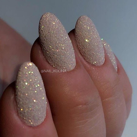 Foto de diseño de uñas con oro en uñas largas.