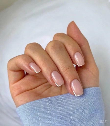 Foto de una hermosa manicura francesa para uñas cortas.